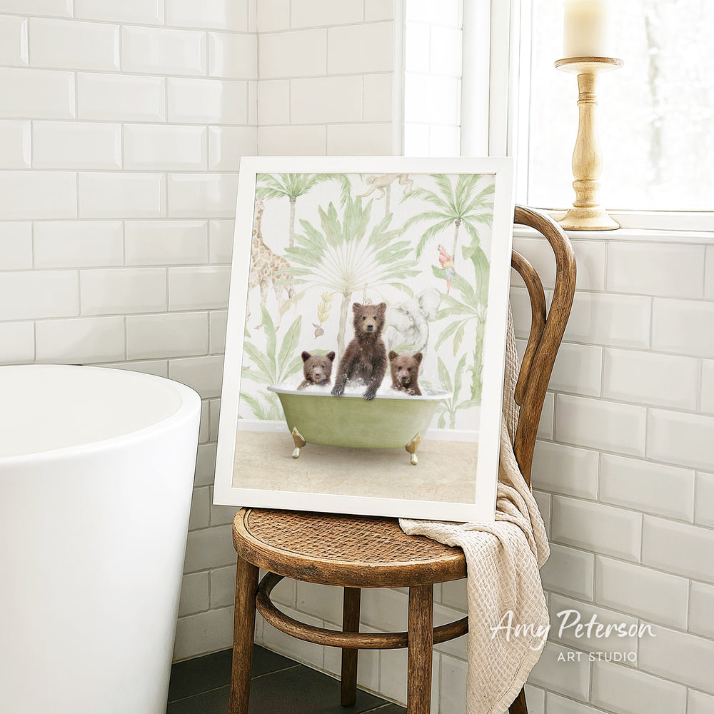 A framed print of a bear cub sitting in a bathtub is displayed on a wooden chair in a bathroom setting.
