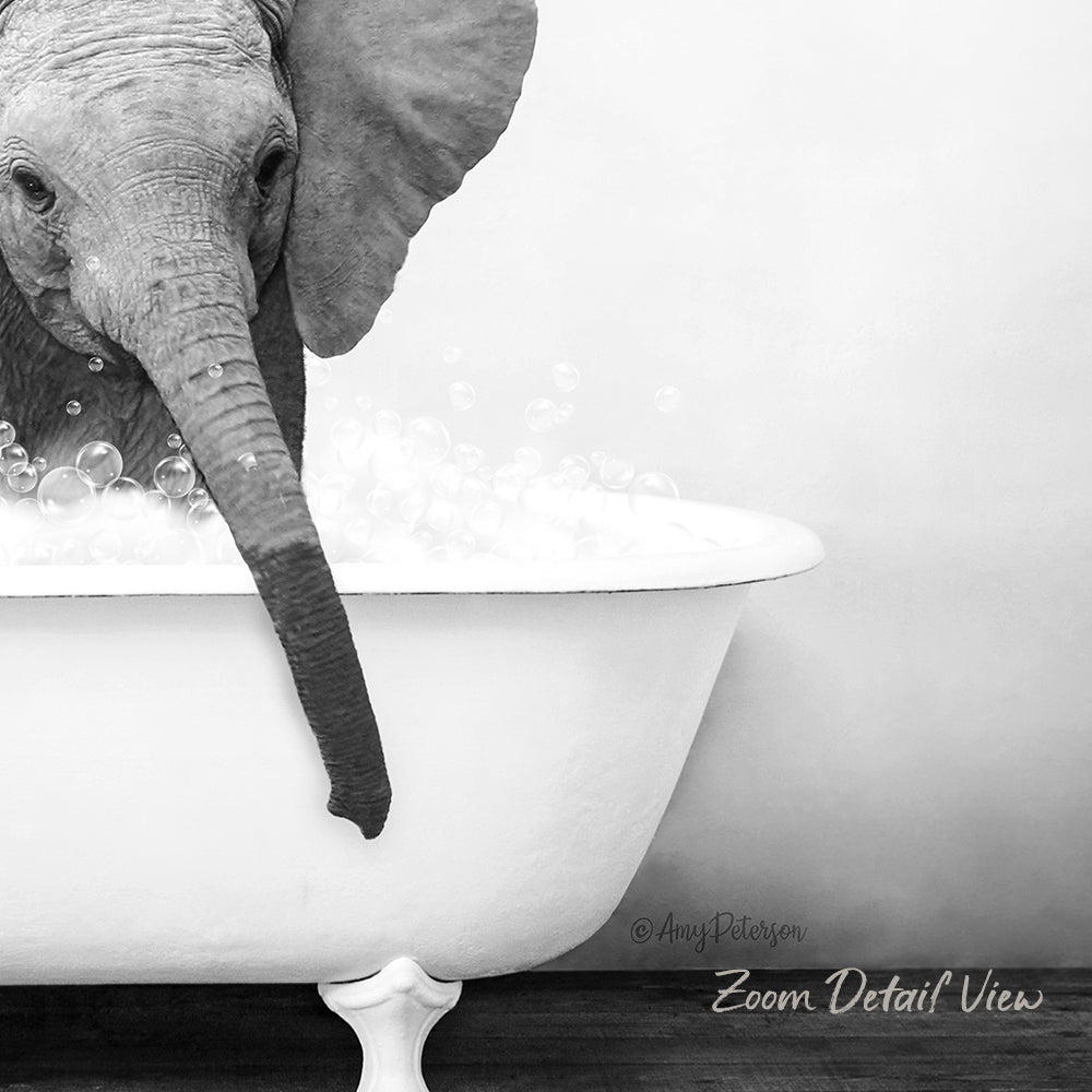 A baby elephant is sitting in a bathtub filled with bubbles, enjoying a bath.