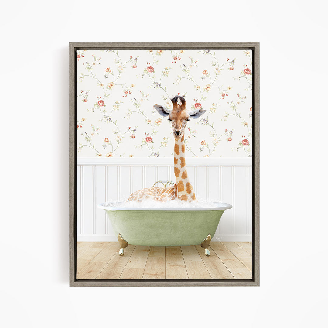 A giraffe is sitting in a green bathtub filled with bubbles, surrounded by a floral wallpaper.