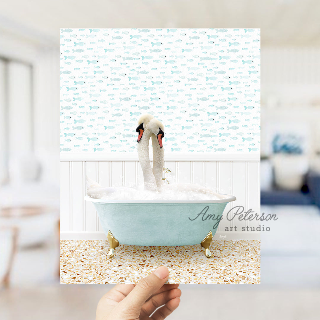 a person holding up a picture of two swans in a bathtub