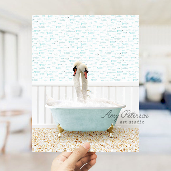 a person holding up a picture of two swans in a bathtub