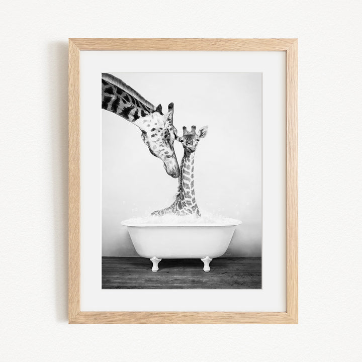 A mother giraffe and her baby giraffe enjoying a bath together in a white bathtub.