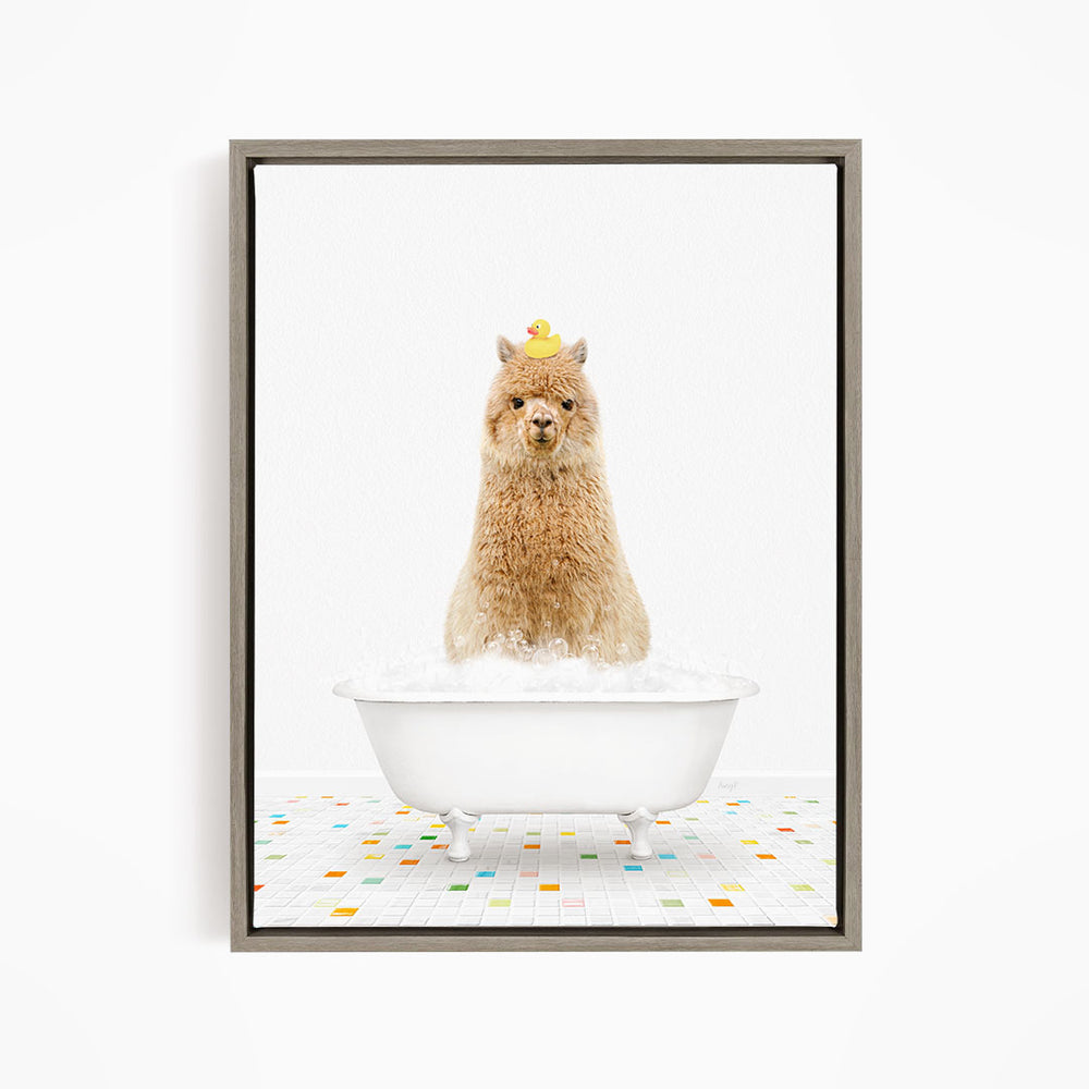 A fluffy brown alpaca sits in a white bathtub filled with bubbles, with a yellow rubber duck perched on its head.