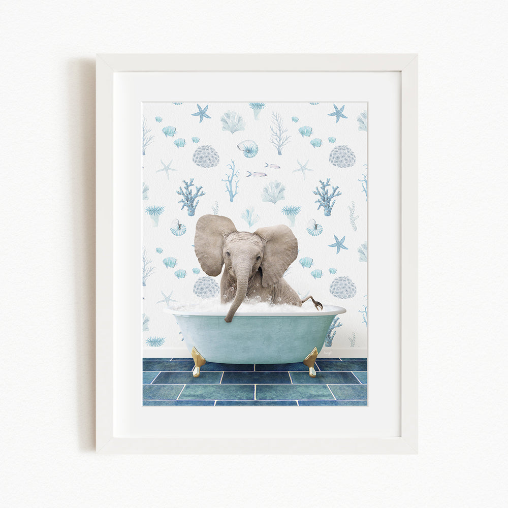 A framed image depicting a baby elephant sitting in a bathtub filled with water, surrounded by a blue and white ocean-themed wallpaper.