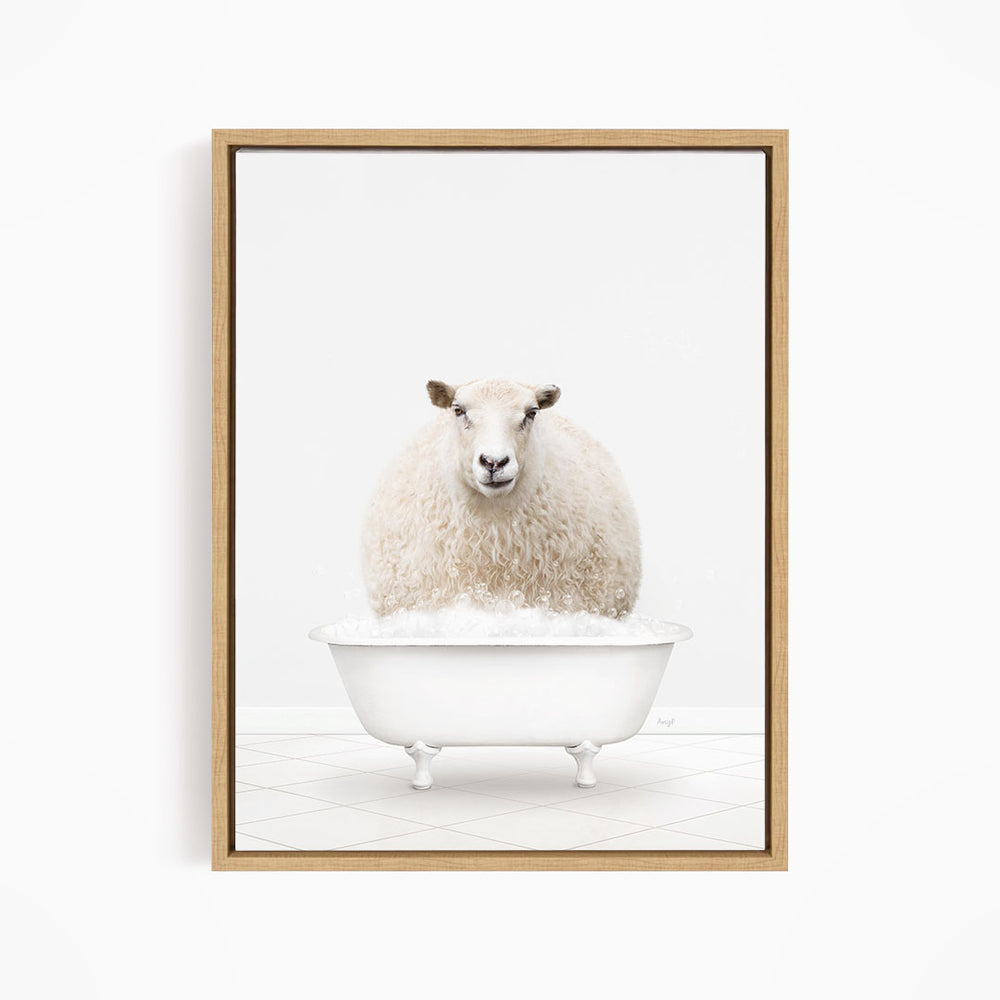 A fluffy white sheep sits in a white bathtub filled with bubbles, looking directly at the camera.