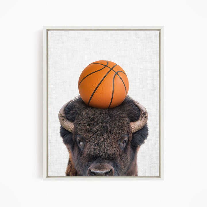 A buffalo with a basketball resting on its head.
