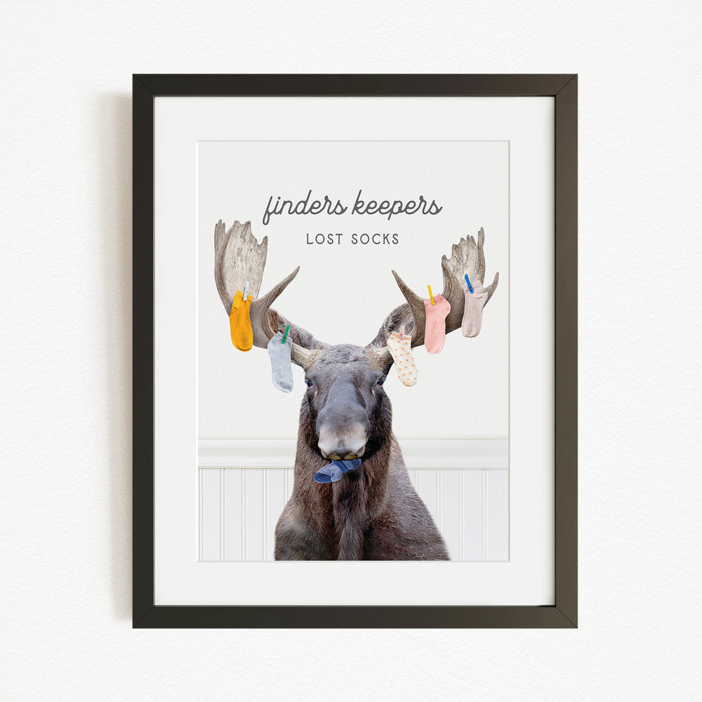A framed image of a moose with a humorous caption that reads "finders keepers lost socks".