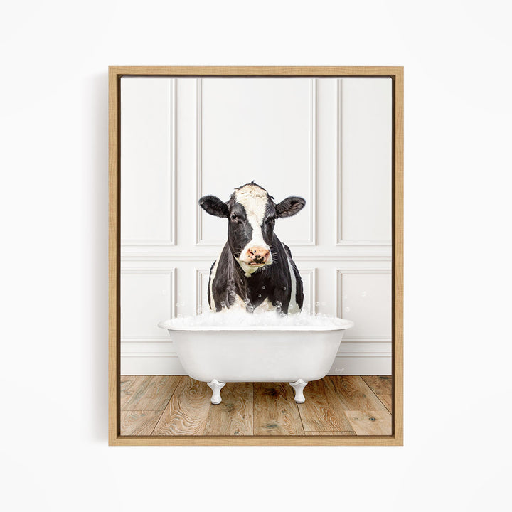 A black and white cow is standing in a white bathtub filled with water, creating a whimsical and humorous scene.
