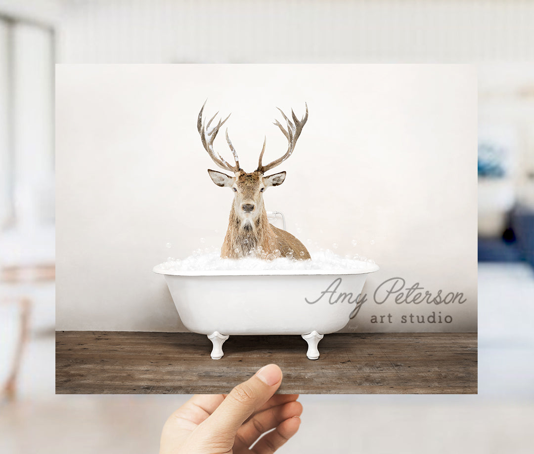 a person holding up a card with a picture of a deer in a bathtub