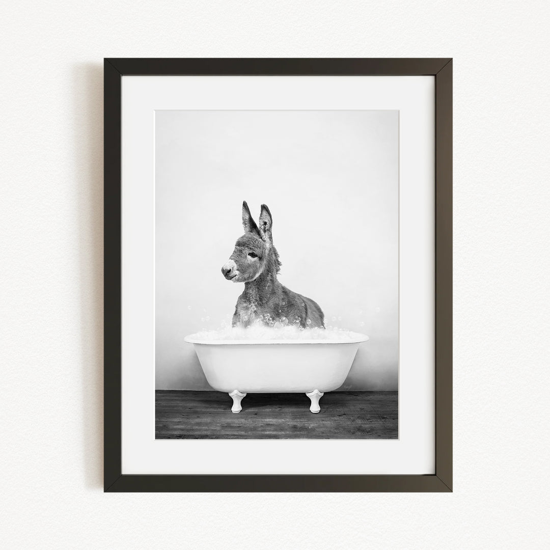 A donkey is sitting in a bathtub filled with water, creating a playful and whimsical scene.