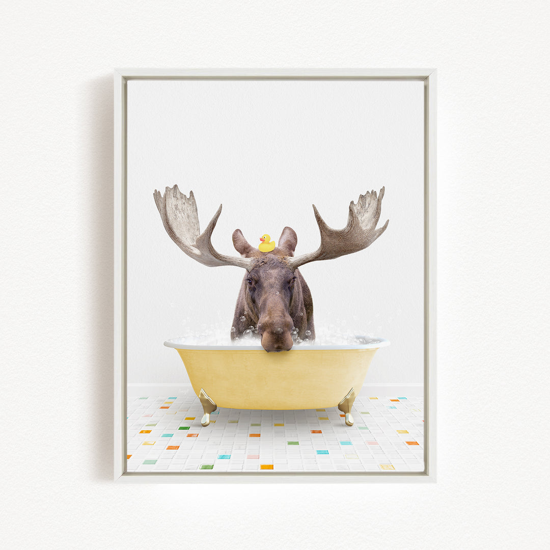 A moose with large antlers is sitting in a yellow bathtub, with a rubber duck perched on its head.