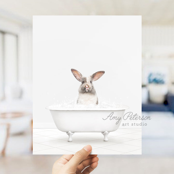 a person holding up a card with a picture of a rabbit in a bathtub