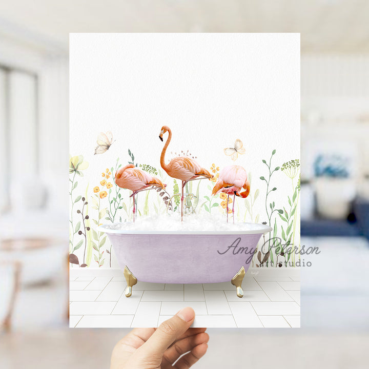 a person holding up a card with flamingos in a bathtub