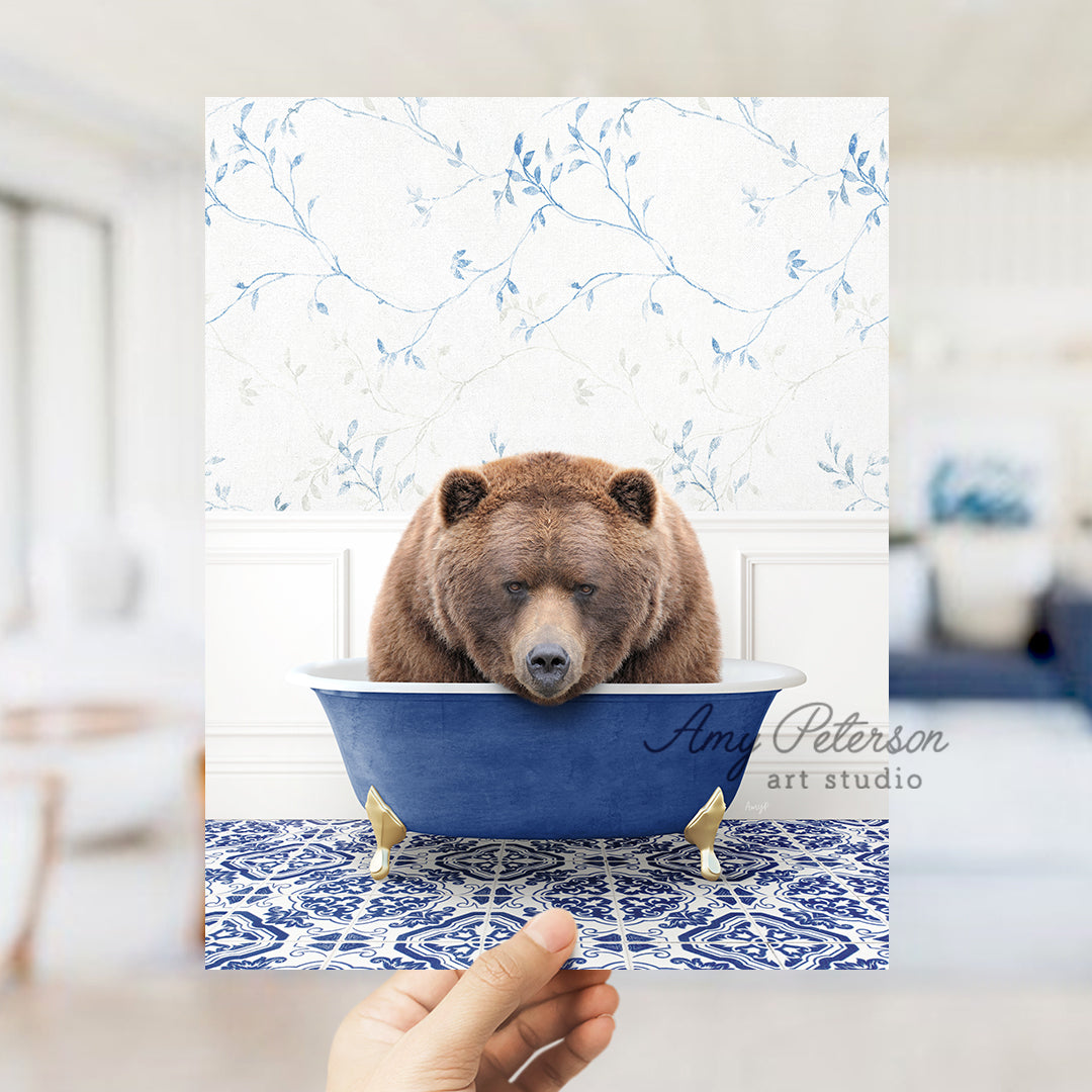 a hand holding a card with a bear in a bathtub