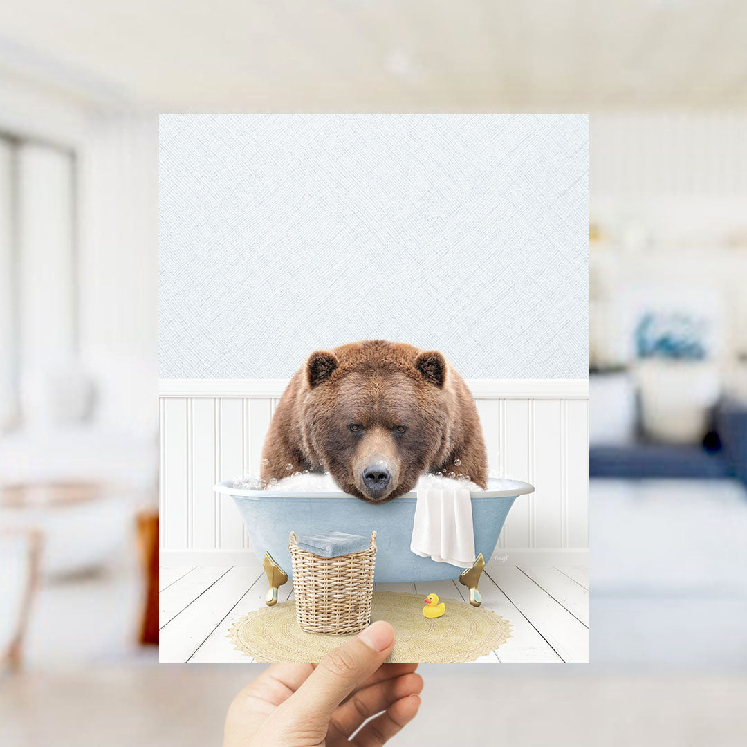A brown bear sitting in a bathtub filled with water, surrounded by a basket of toys and a yellow rubber duck.