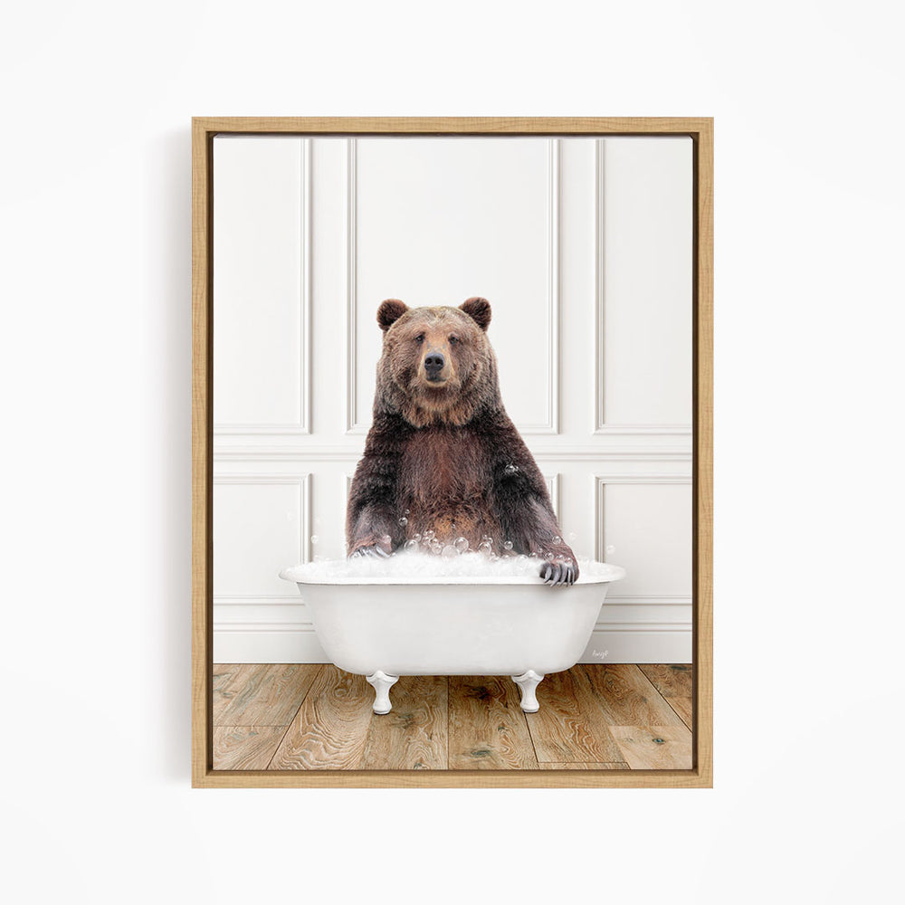 A brown bear sitting in a white bathtub, appearing to enjoy the bath.