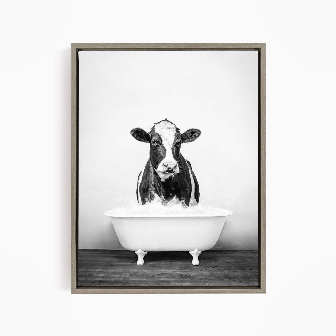 A black and white image of a cow standing in a bathtub filled with water.