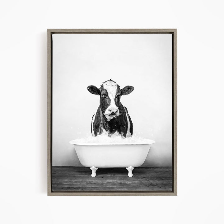 A black and white image of a cow standing in a bathtub filled with water.