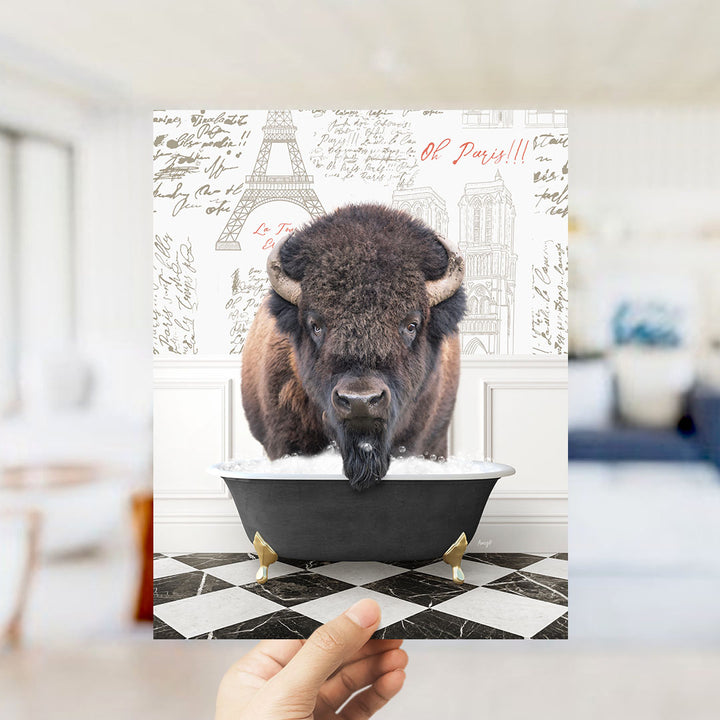 A buffalo is sitting in a bathtub filled with water, with the Eiffel Tower and Paris in the background.