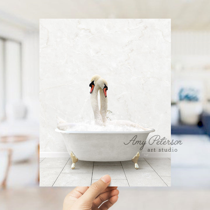 a person holding a picture of two swans in a bathtub