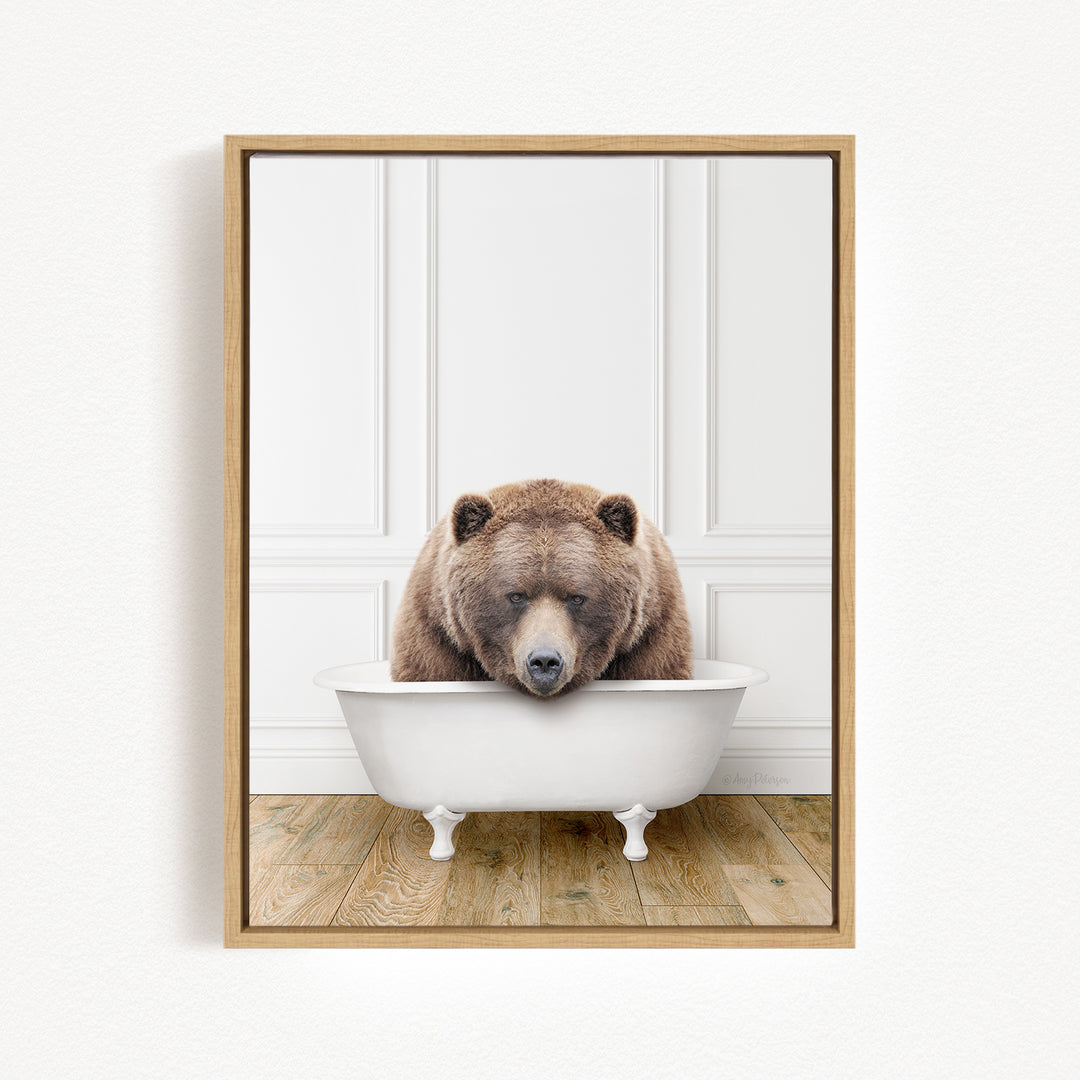 A brown bear is sitting in a white bathtub, appearing relaxed and content.
