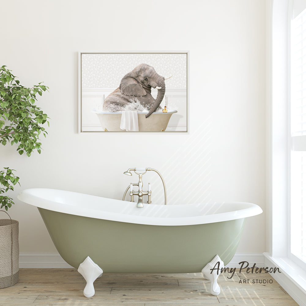 A framed image of an elephant sitting in a bathtub is displayed on the wall above a green clawfoot bathtub in a modern bathroom.