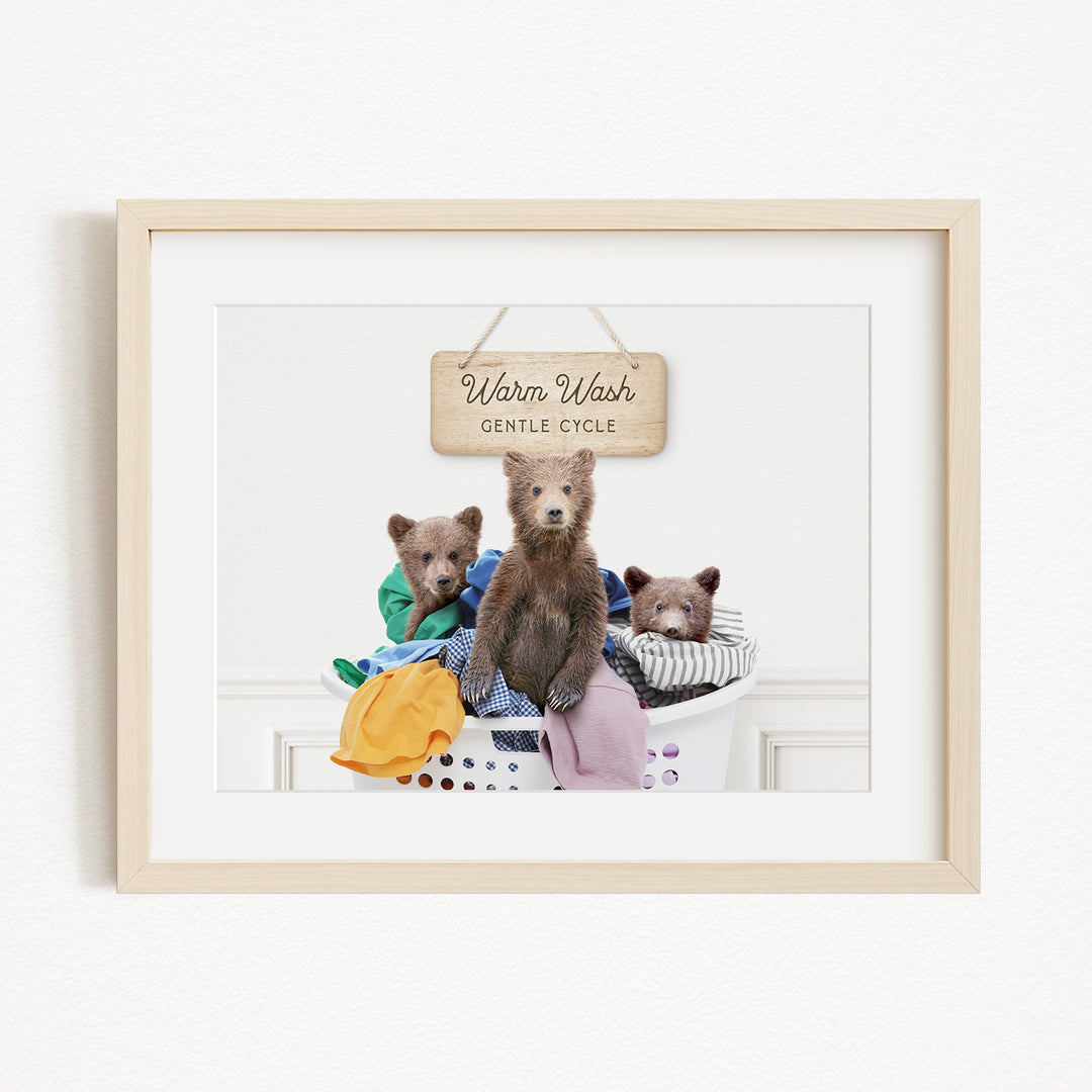 A framed image of three bears sitting in a laundry basket, with a sign above them that reads "Warm Wash Gentle Cycle".