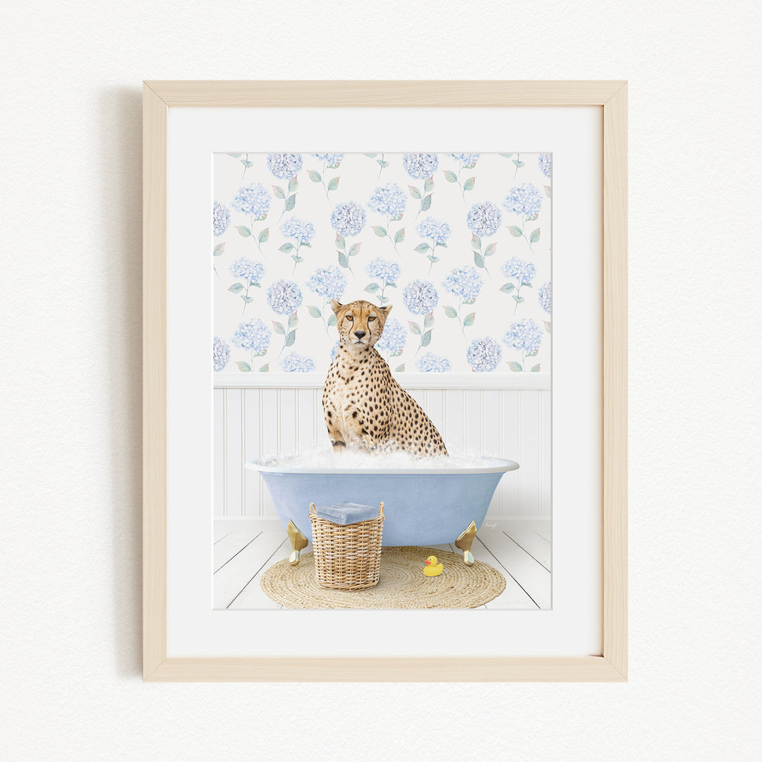 A cheetah sitting in a blue bathtub filled with water, surrounded by a floral patterned wall and a basket of rubber ducks.