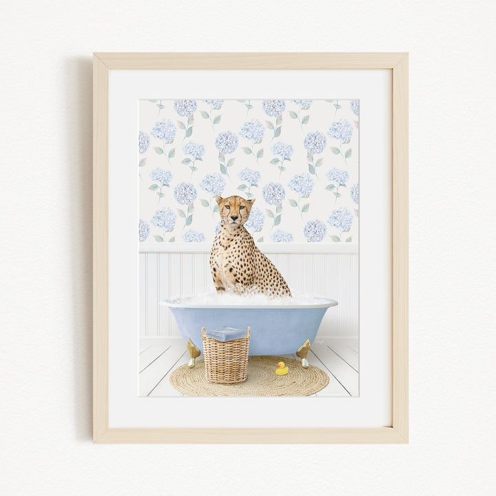 A cheetah sitting in a blue bathtub filled with water, surrounded by a floral patterned wall and a basket of rubber ducks.