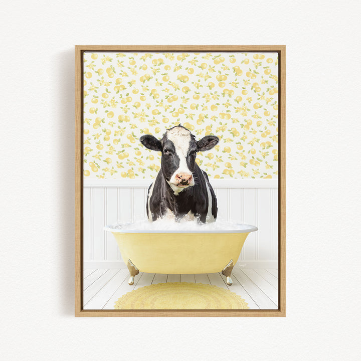 A black and white cow is sitting in a yellow bathtub filled with water, surrounded by a yellow floral pattern on the wall behind it.