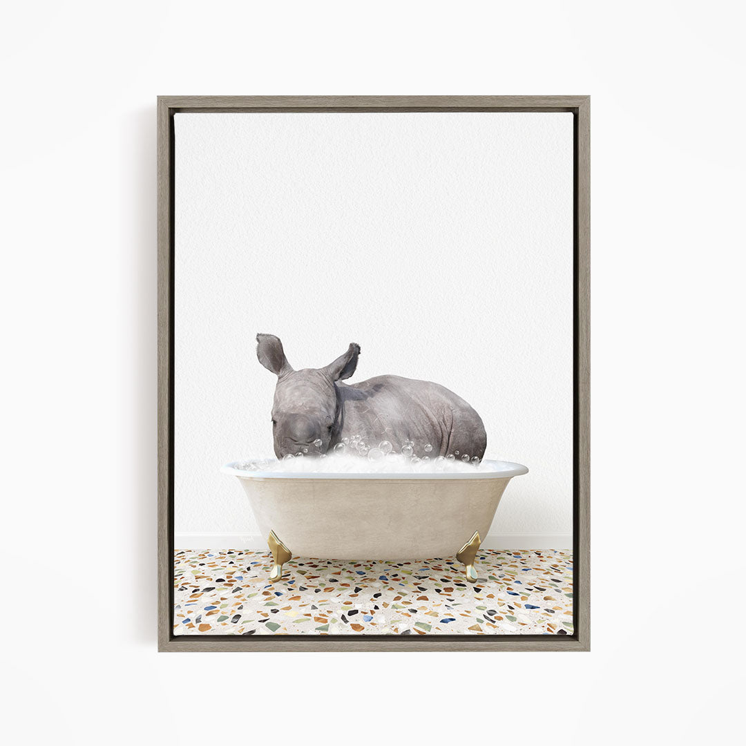 A rhinoceros is sitting in a bathtub filled with water, creating a whimsical and playful scene.
