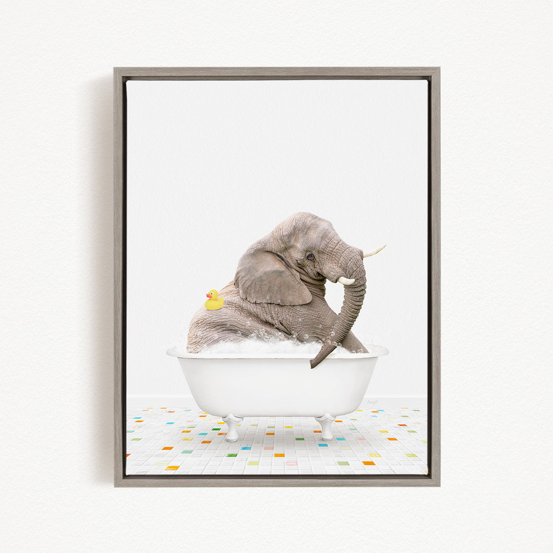 A gray elephant is sitting in a white bathtub, with a yellow rubber duck floating next to it.