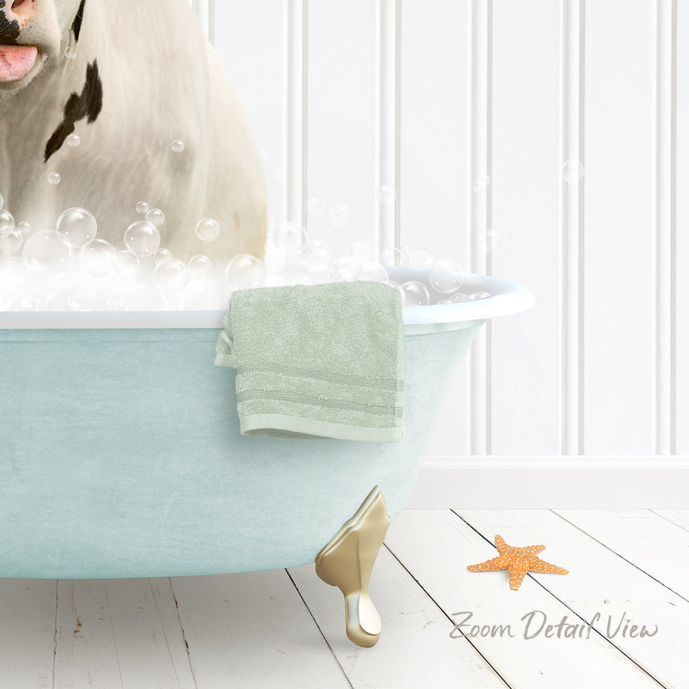 A white dog is sitting in a light blue bathtub filled with bubbles, with a towel and starfish nearby.