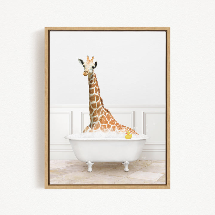 A giraffe sitting in a white bathtub filled with bubbles, with a yellow rubber duck floating in the water.