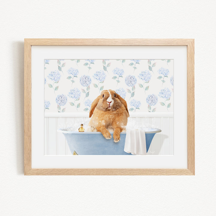 A brown rabbit sitting in a blue bathtub filled with water, surrounded by a floral pattern on the wall behind it.
