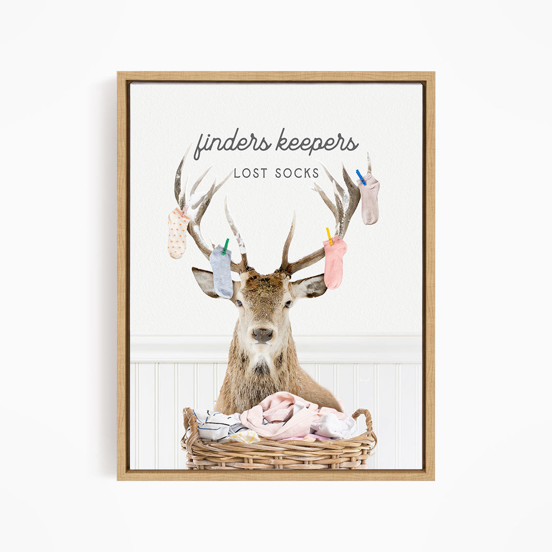 A deer with antlers holding socks in its mouth, standing in a basket filled with clothes.