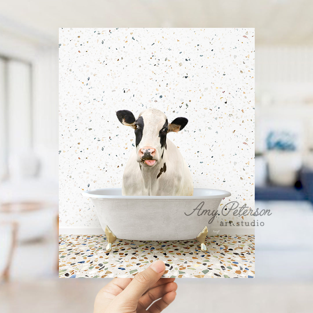 a hand holding up a card with a picture of a cow in a bathtub