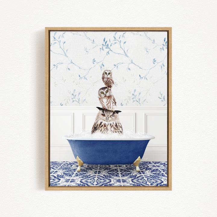 A framed image depicting three owls sitting in a blue bathtub, with a patterned tile floor and a floral wallpaper in the background.