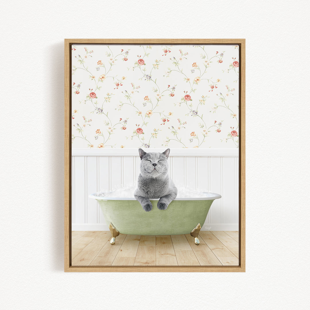 A gray cat sitting in a green bathtub, with a floral wallpaper in the background.