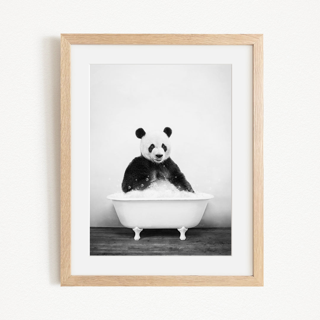 A panda bear sitting in a white bathtub filled with bubbles, creating a whimsical and playful scene.