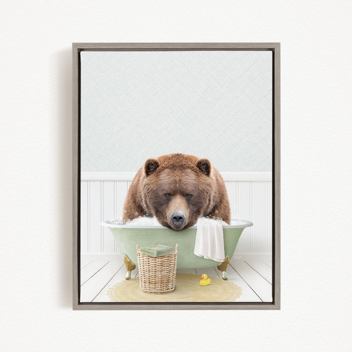 A brown bear is sitting in a green bathtub, surrounded by a basket, a rubber duck, and a towel, in a bathroom setting.