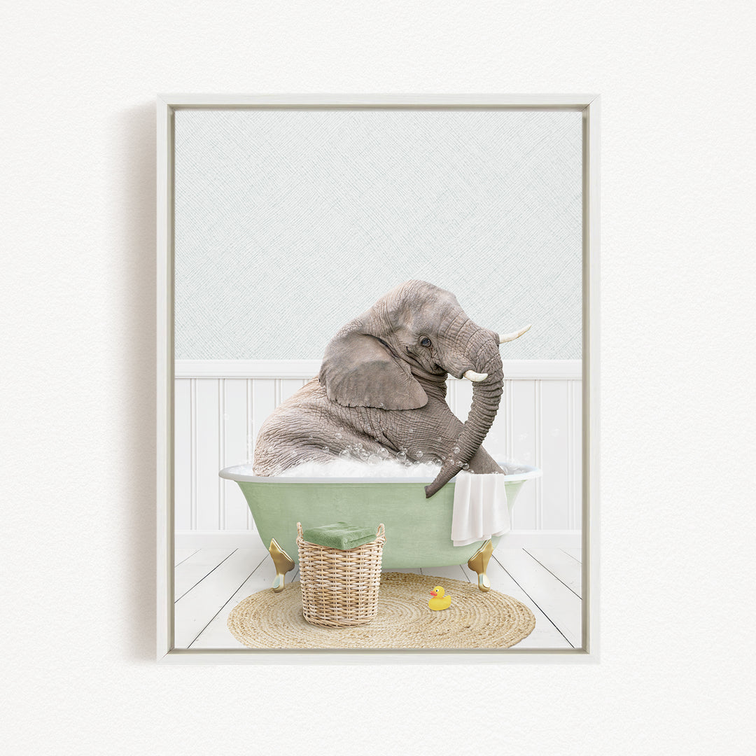 A gray elephant is sitting in a green bathtub filled with water, surrounded by a yellow rubber duck and a woven basket.