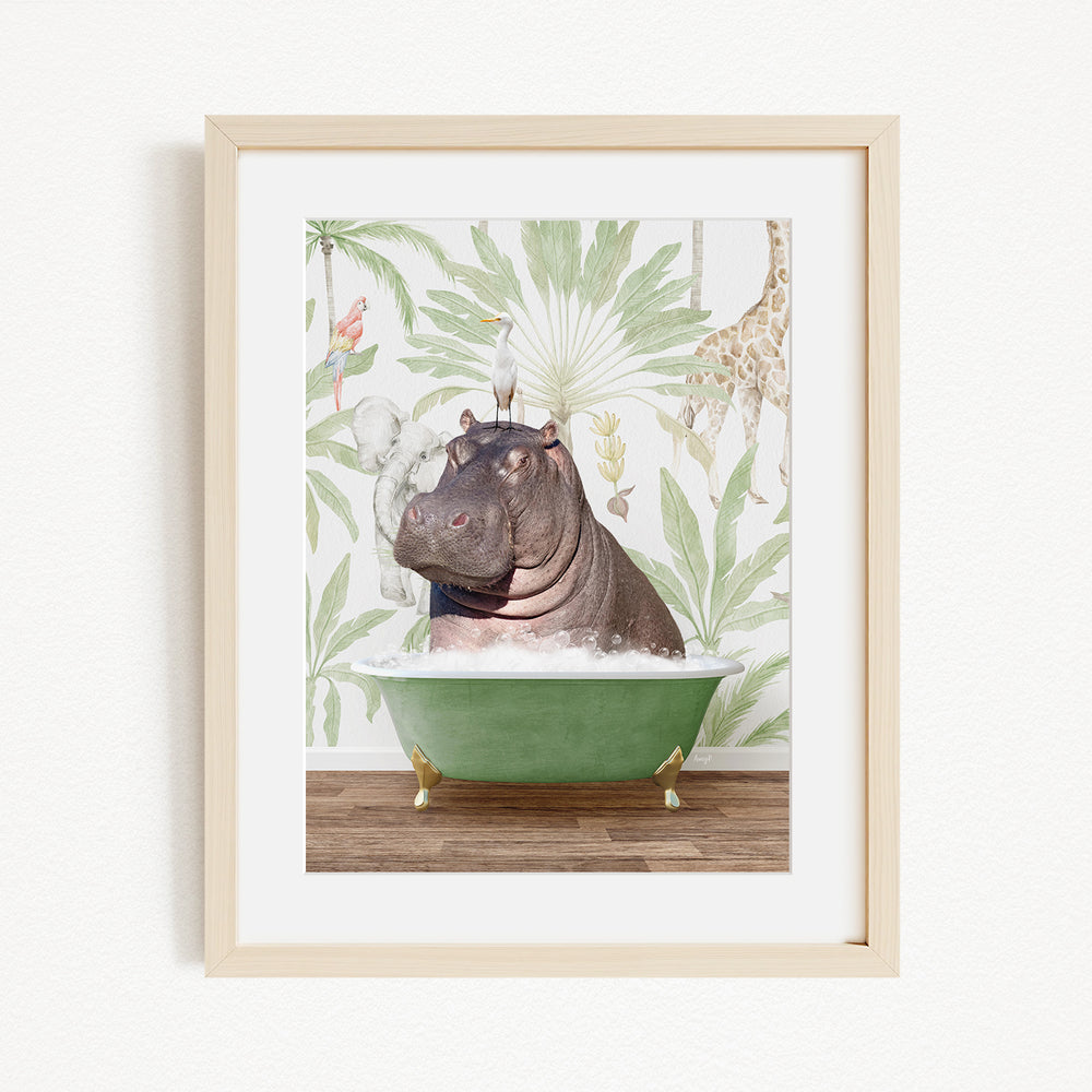 A framed image depicting a hippopotamus sitting in a green bathtub, surrounded by tropical foliage and a bird.