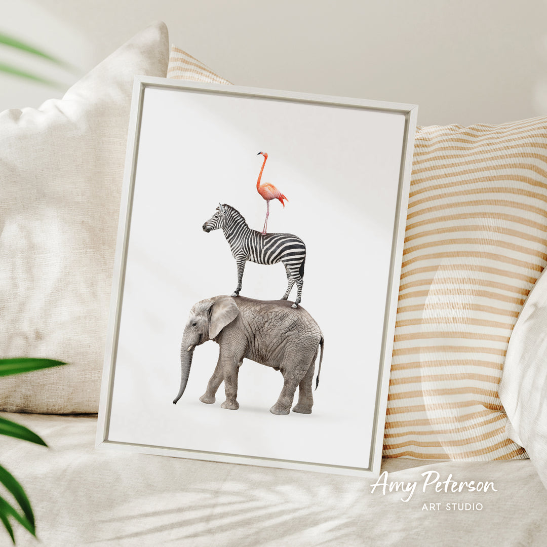 A framed print of a zebra standing on the back of an elephant, with a pink flamingo perched on top of the zebra.