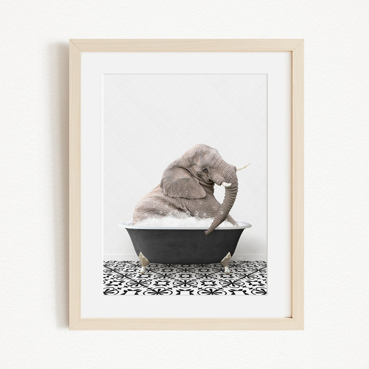 A gray elephant sitting in a black bathtub filled with water, surrounded by a black and white patterned floor.