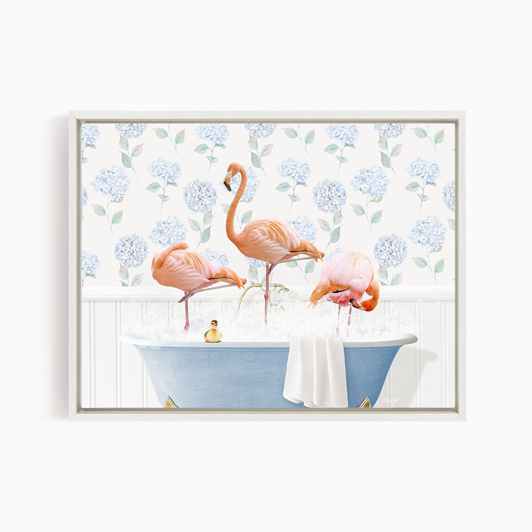 A framed image depicting three flamingos standing in a blue bathtub filled with water, surrounded by a floral patterned wall.