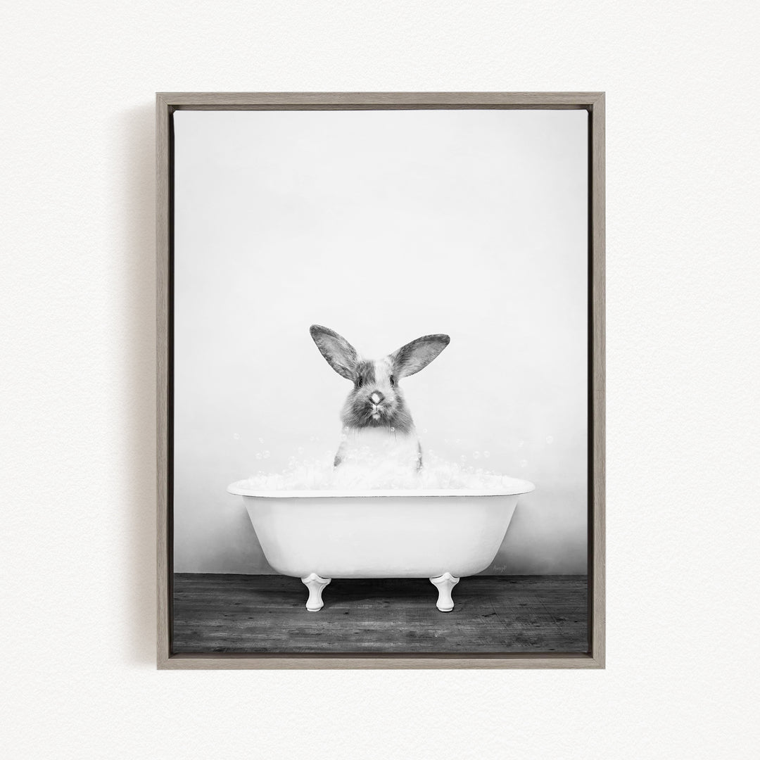 A black and white image of a rabbit sitting in a bathtub filled with water.