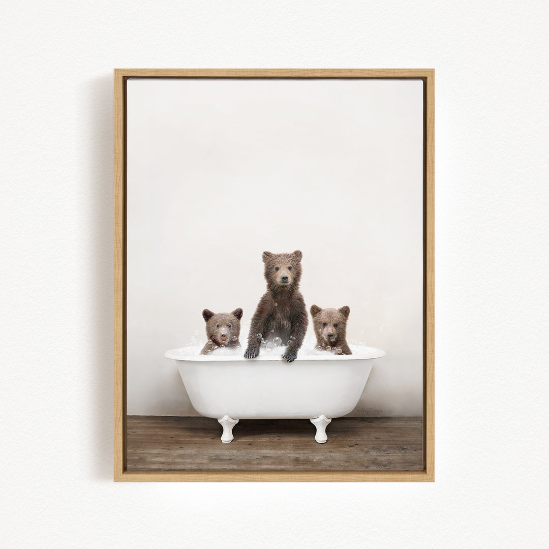 A framed image showing three brown bears sitting in a white bathtub, with one bear sitting at the center and the other two bears sitting on either side.