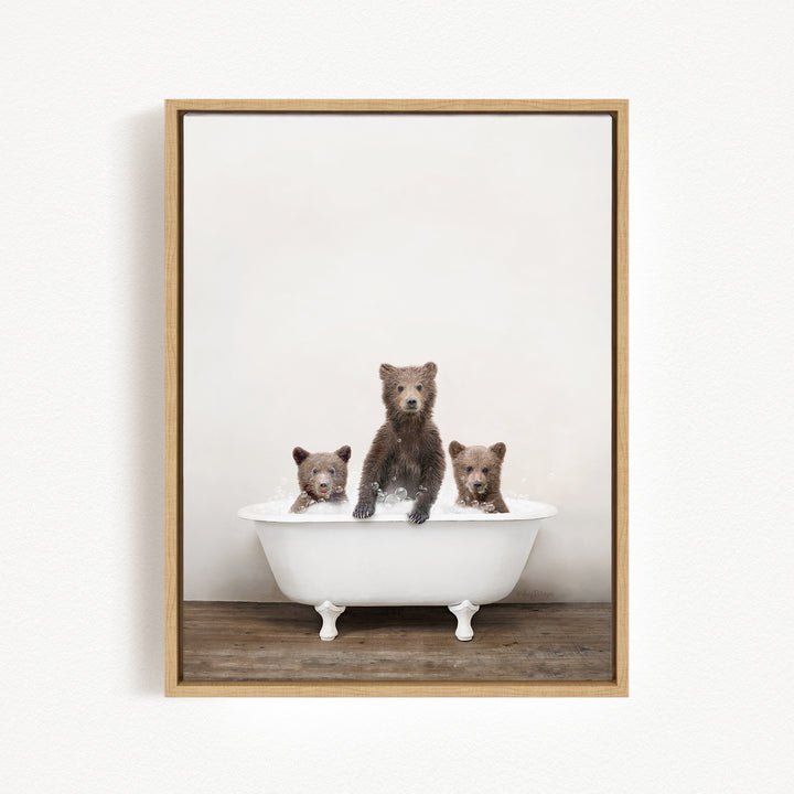 A framed image showing three brown bears sitting in a white bathtub, with one bear sitting at the center and the other two bears sitting on either side.