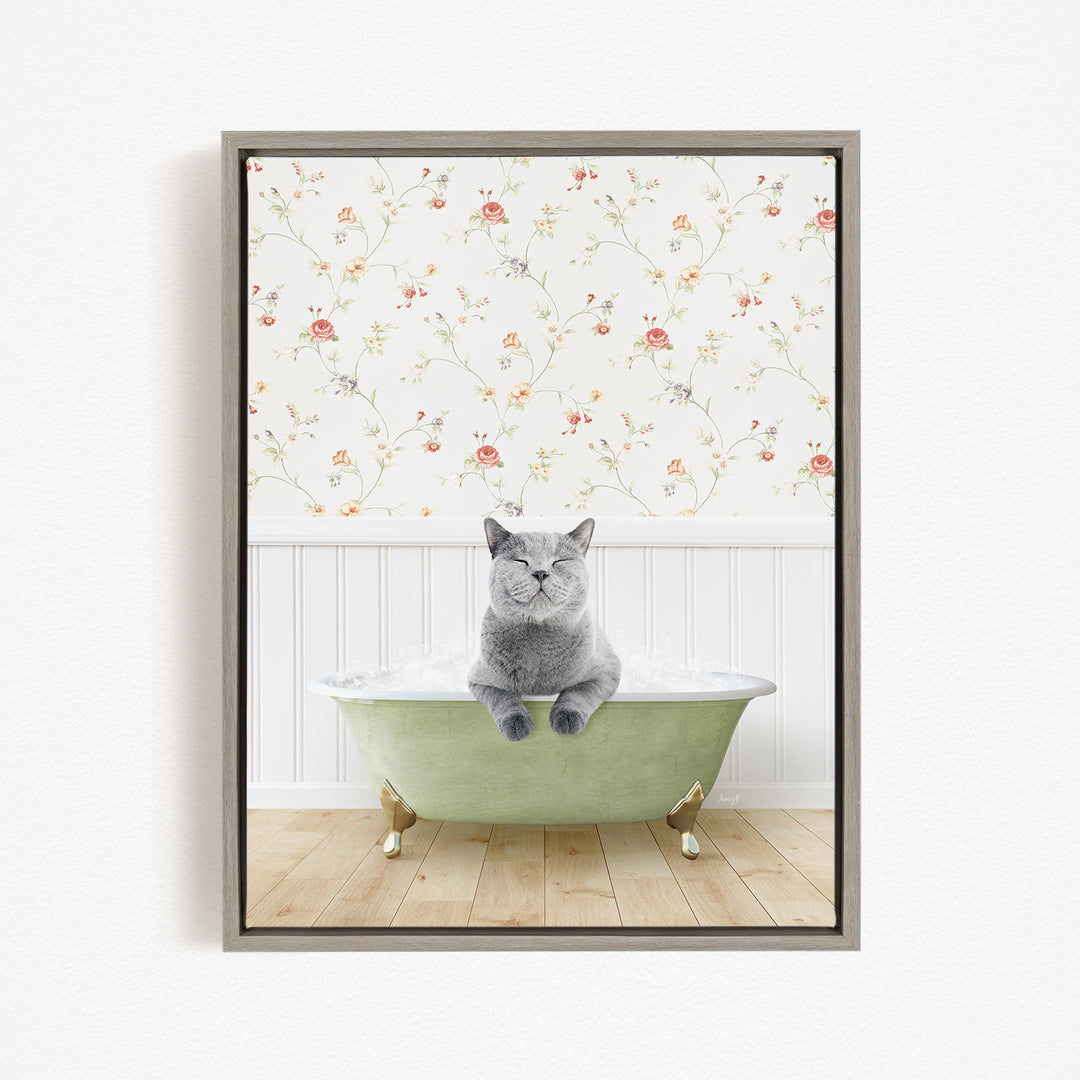 A gray cat sitting in a green bathtub, with a floral wallpaper in the background.